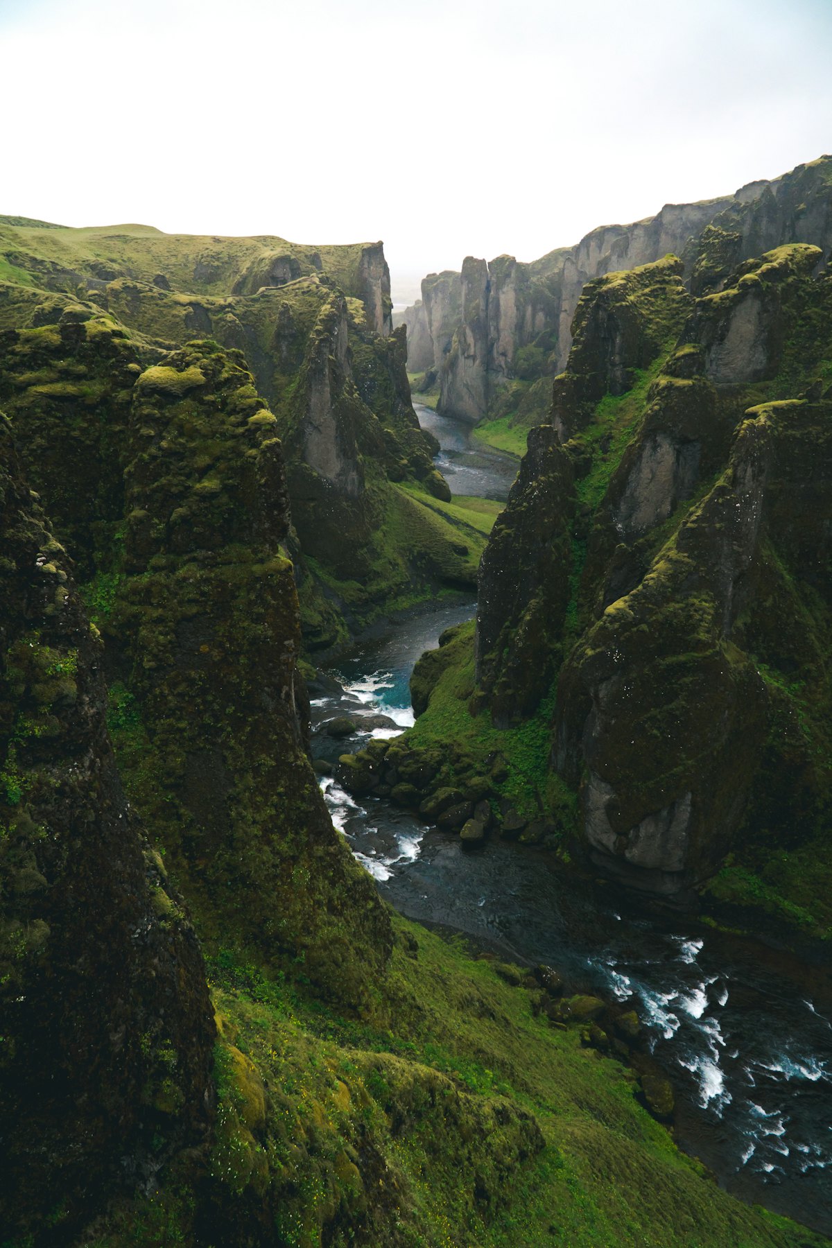 A river winding through a deep, moss-covered canyon