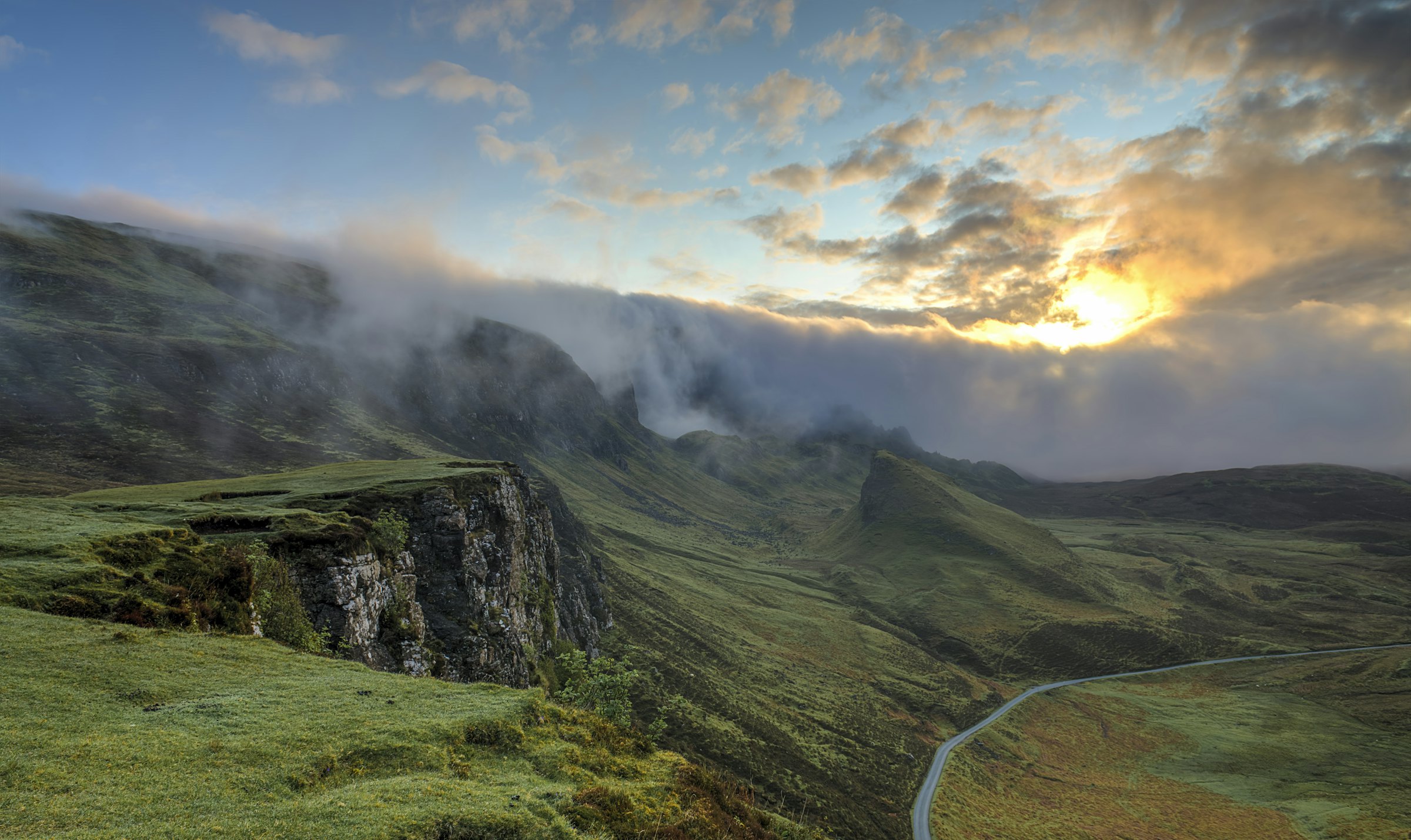 Morning mist drifting over green mountain ridges